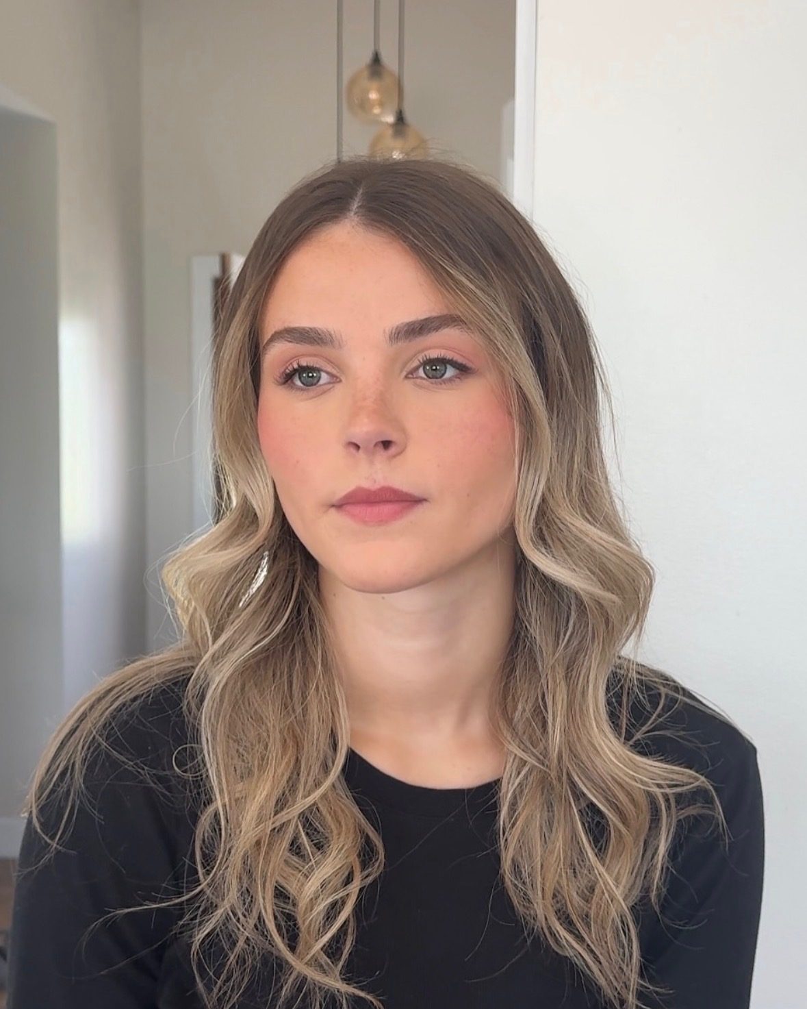Client in a soft, natural makeup look with freckles showing through — fresh and skin-first